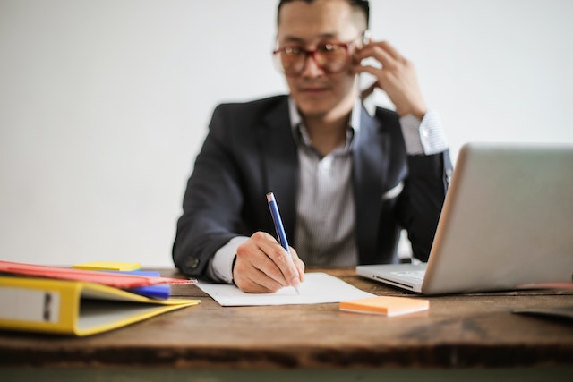 a out of focus person talking on the phone at a desk